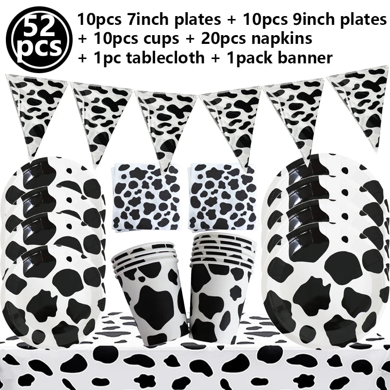 A collection of cow print tableware including plates, cups, napkins, a tablecloth, and a banner for a farm-themed party.