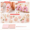 A collection of pink and white polymer clay beads, flowers, charms, and decorations for nail art and DIY crafts.