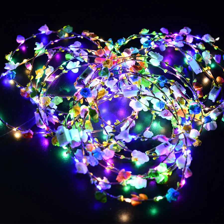 A glowing flower wreath headband with multiple colored LEDs illuminates a dark background.
