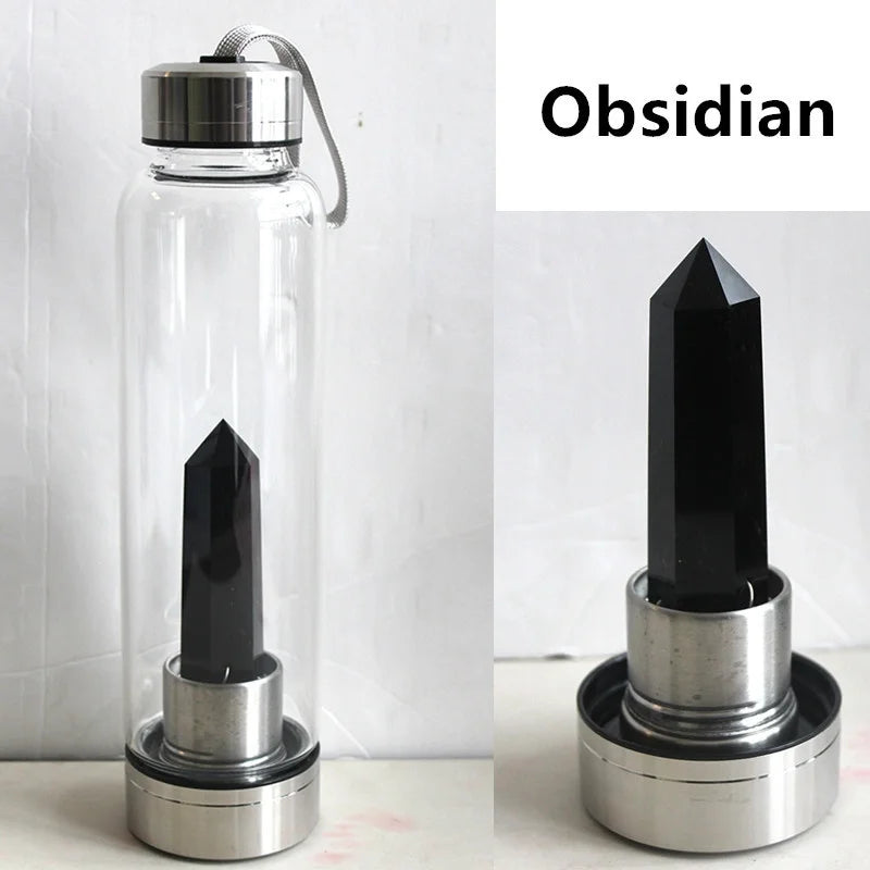 Botella de agua de vidrio transparente con un cristal de obsidiana negro, sobre fondo blanco.