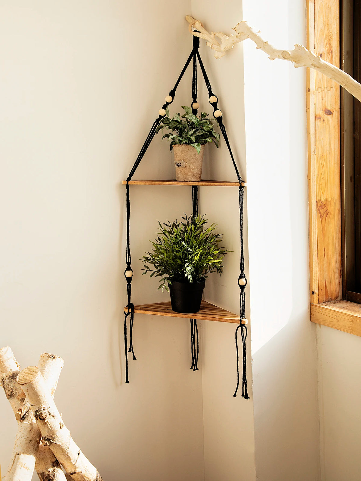 Étagère flottante en bois bohème avec suspensions en macramé, exposant de la verdure en pots sur un mur clair.