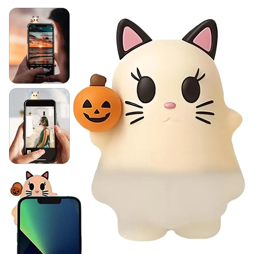A white cat-shaped LED light decoration with black ears and whiskers, featuring a carved pumpkin face.