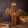 A carved wooden cross featuring a crown of thorns, used as wall decor.