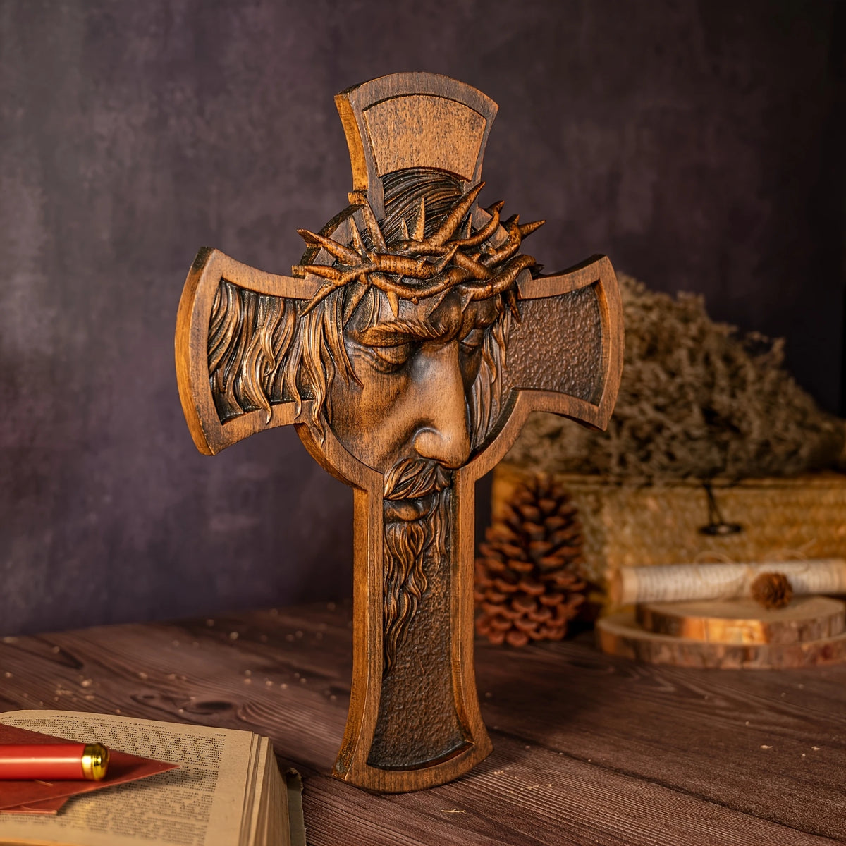 A carved wooden cross featuring a crown of thorns, used as wall decor.