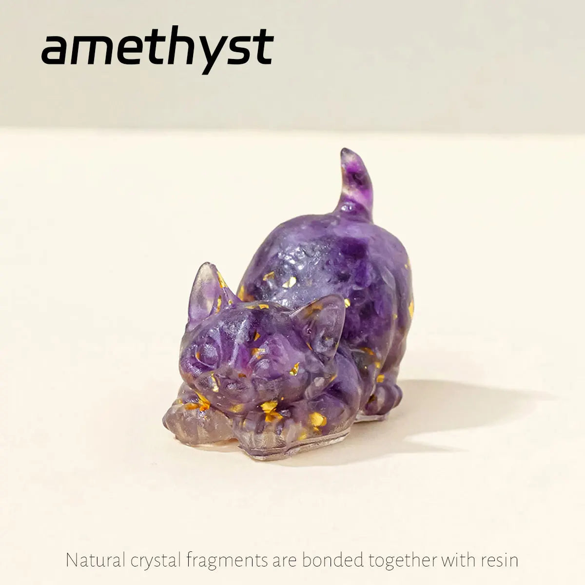 A small, purple crystal figurine shaped like a crouching cat, made by bonding natural crystal fragments with resin.