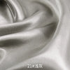 Close-up of smooth, lustrous gray satin fabric draped and folded for sewing or DIY projects.
