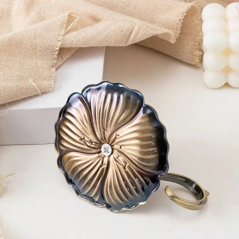 Porte-bougie lotus en fer forgé vintage avec finition martelée sur une surface claire.
