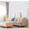 A modern living room featuring a light gray sofa against a white brick wall panel and a wooden coffee table.