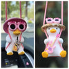 A cute pink anime duck ornament with large eyes and a crown, hanging from a string.