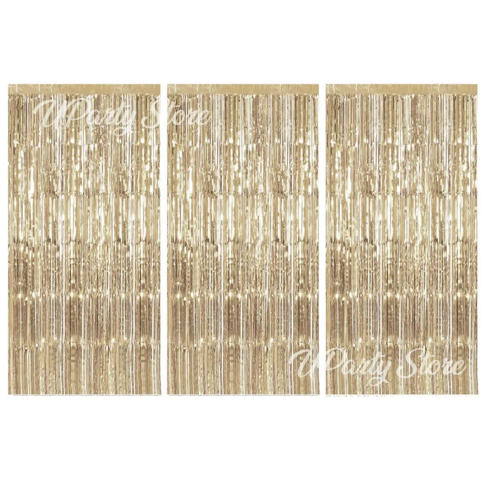 Three panels of metallic gold foil fringe curtains hanging vertically for party backdrop decor