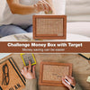 Hands are placing coins into a wooden savings box with a progress tracker on top.
