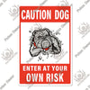 A vintage warning metal sign with the text CAUTION DOG and ENTER AT YOUR OWN RISK featuring a bulldog illustration.