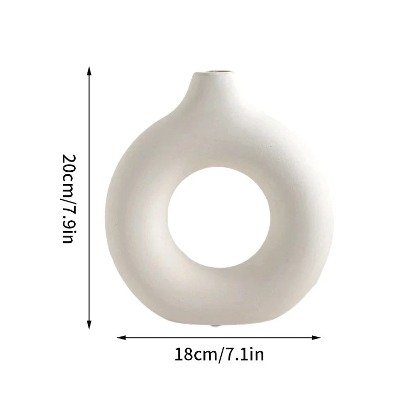 A white ceramic-style vase with a smooth, rounded body and a large circular opening.