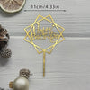 A gold acrylic birthday cake topper featuring the words Happy Birthday in a geometric design on a stick.