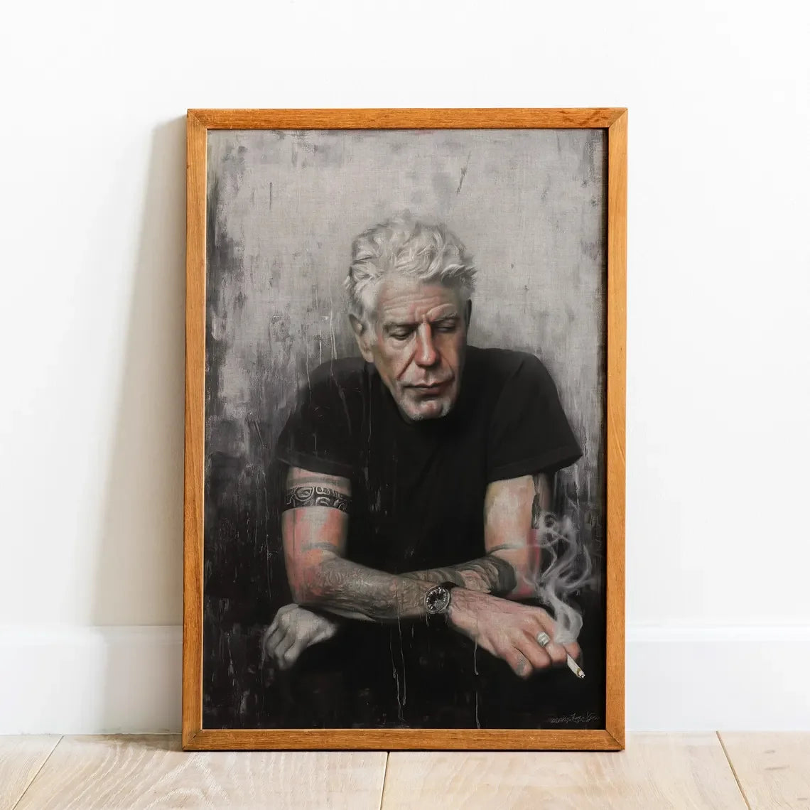 A framed black and white portrait photograph of an older man with white hair looking down.