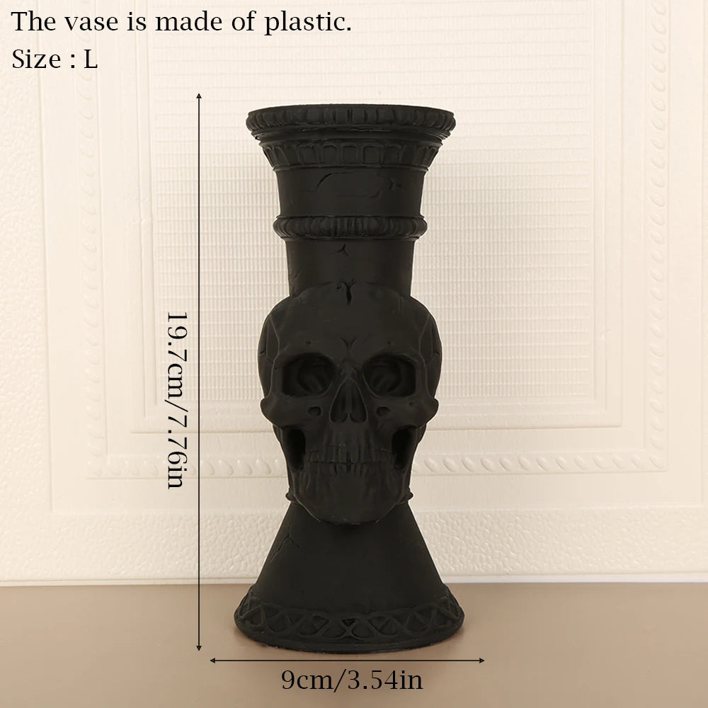 A black plastic skull-shaped vase with a cylindrical body and flared base.