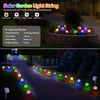 A string of solar powered bubble ball garden lights illuminating a pathway in a garden setting.