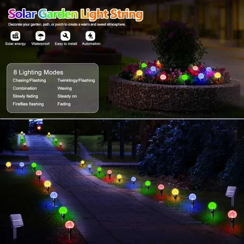 A string of solar powered bubble ball garden lights illuminating a pathway in a garden setting.