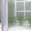 Vertical frosted window privacy film with horizontal stripes providing diffused light and privacy.