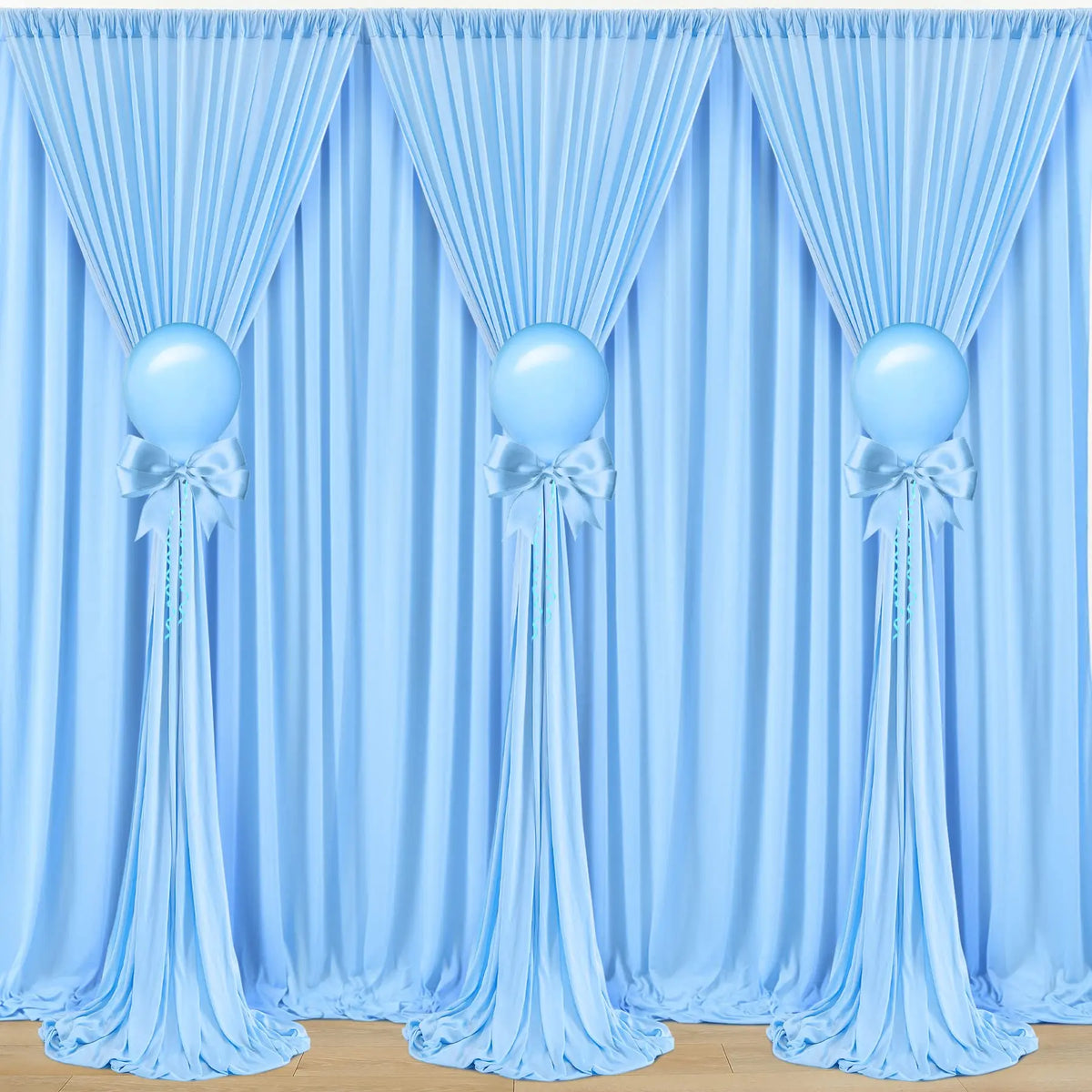 Elegant blue fabric party backdrop featuring draped curtains and spherical blue balloons