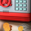 A red and silver password saving piggy bank with a keypad and gold coins on a surface.