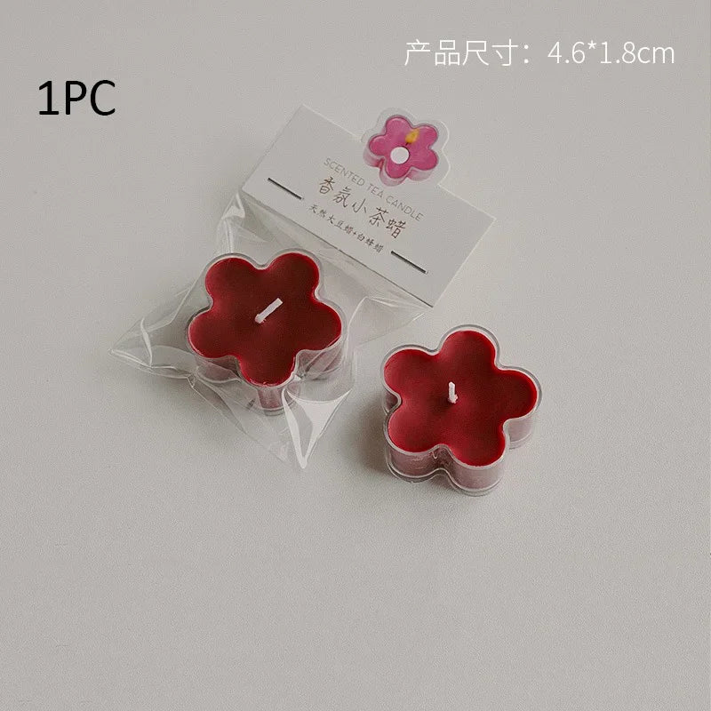 A single red soy wax flower tea light candle in clear packaging with a pink flower charm.