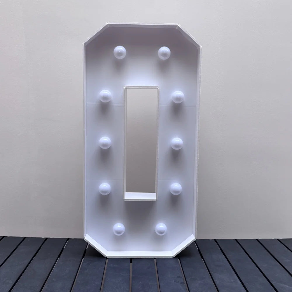 A vertical white light-up marquee sign with a rectangular mirror and surrounding glowing orbs displayed on a dark wooden surf