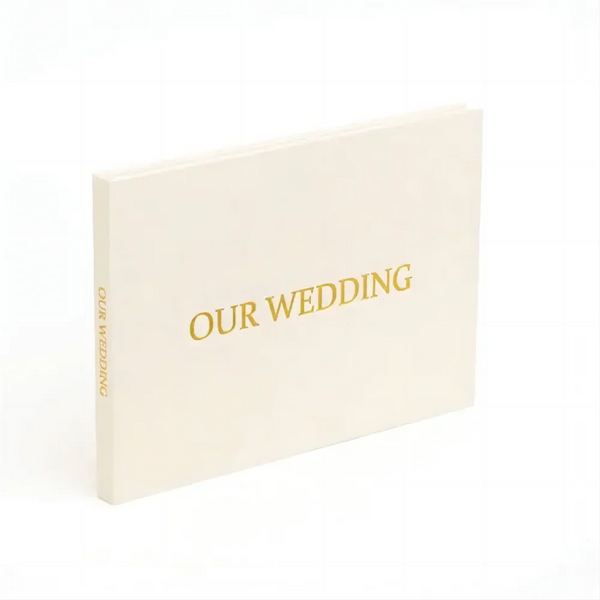 A cream-colored linen bound card with gold text that reads Our Wedding.