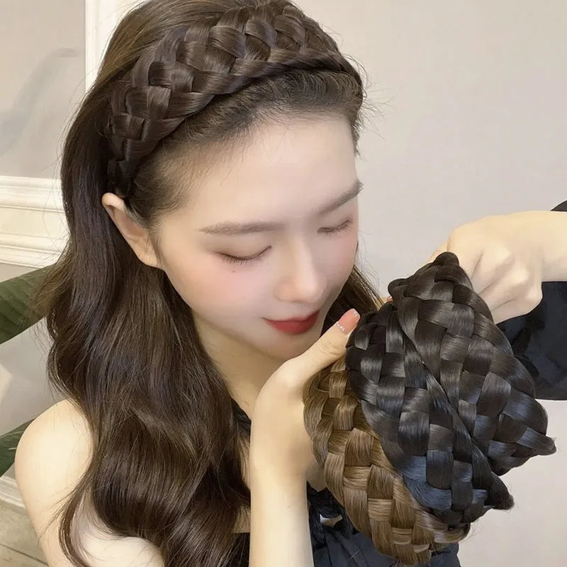 A woman shows off a dark brown braided hair band accessory on her head and hair.