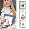 A woman holds a spiral-bound gift card book featuring Christmas designs and a festive holiday greeting.