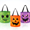Trois citrouilles lumineuses Jack-o'-lantern en distributeurs de bonbons pour Halloween, dans les tons vert, orange et violet