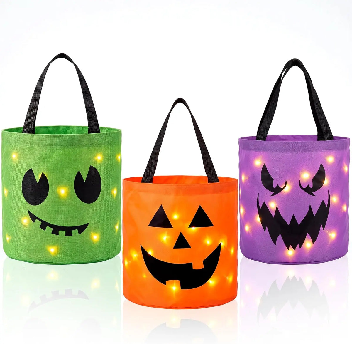 Trois citrouilles lumineuses Jack-o'-lantern en distributeurs de bonbons pour Halloween, dans les tons vert, orange et violet