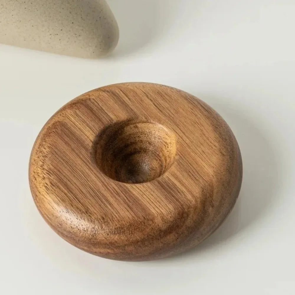 A round ceramic coffee mug with a wooden base resting on a white surface.