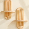 Two wooden wall shelves with concentric vertical grooves mounted on a light-colored wall.