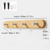 A light wood wall hook rack featuring four wooden hooks for hanging items.