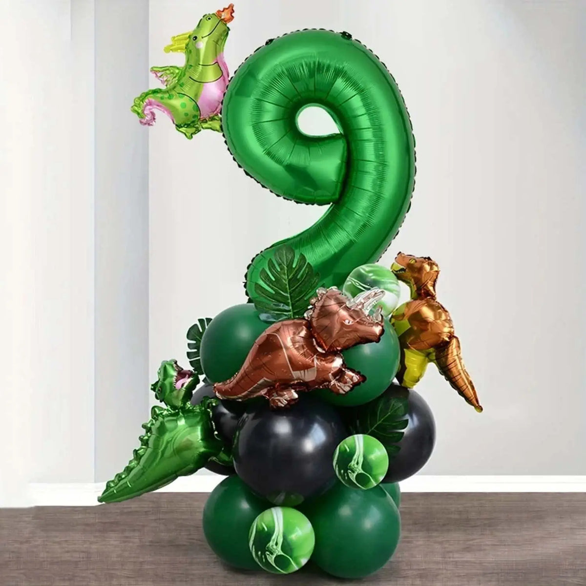 A green balloon set shaped like the number 9 and various dinosaur-themed balloons for a party decoration.