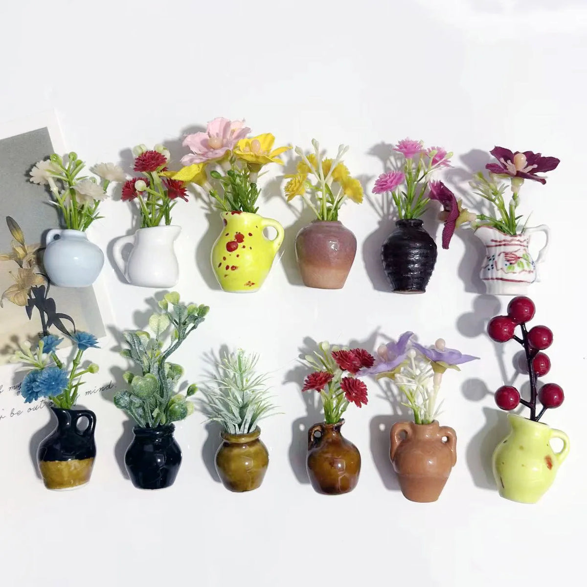 A collection of mini ceramic vases with artificial flowers in various colors and textures.