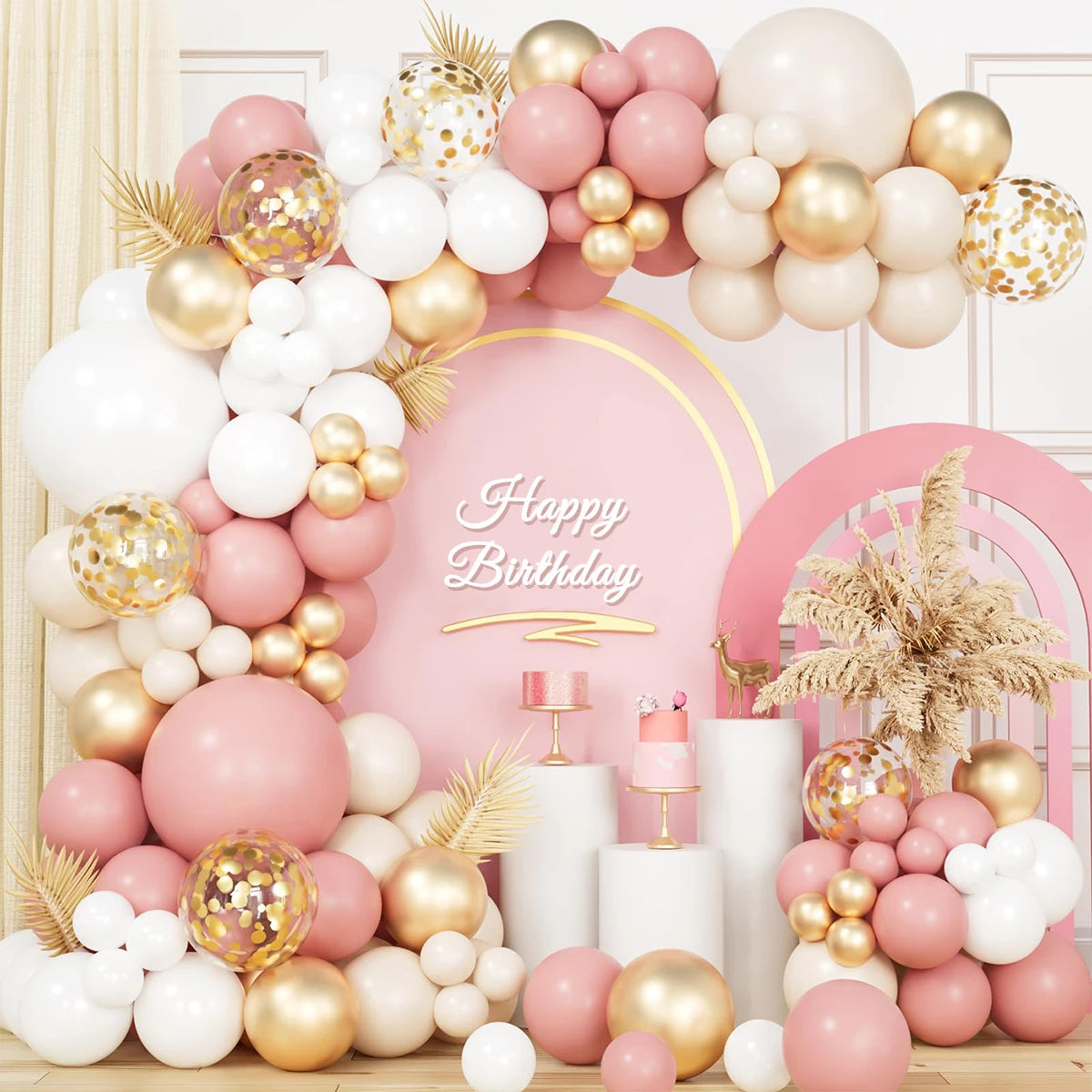 A large arrangement of pink, gold, and white latex balloons with bows for a birthday celebration backdrop.