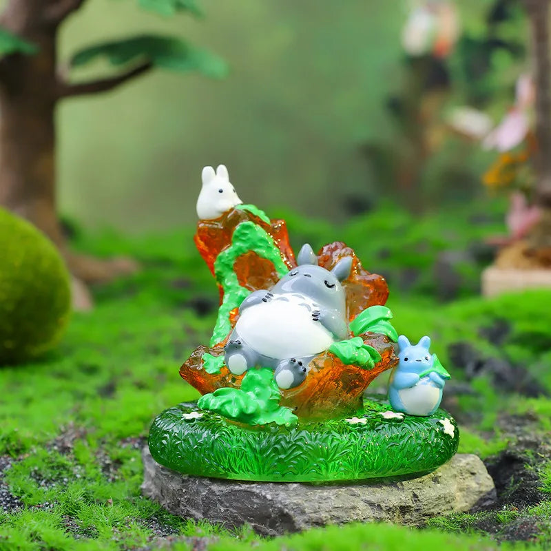 A blind box ornament featuring a white animal figurine sitting on mossy terrain with green foliage.
