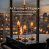 Three glass pillar candle holders with glowing candles displayed on a black piano surface against a city skyline.