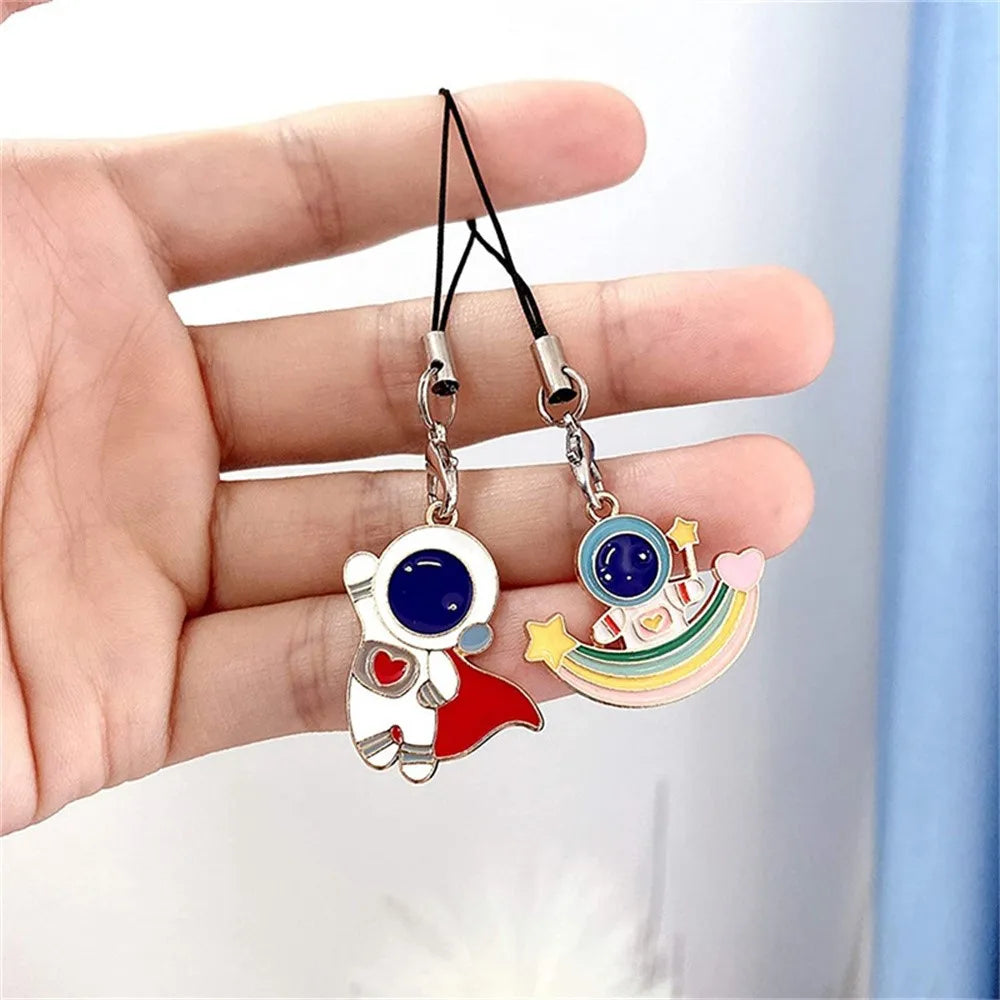 A hand holds a silver and blue charm necklace with a colorful pendant and black lanyard straps.