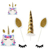 Unicorn cake decoration set featuring a tiered cake, horn, flowers, stars, and balls.