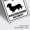 A black silhouette of a Dachshund dog on a white sign with the text DACHSHUND SECURITY.
