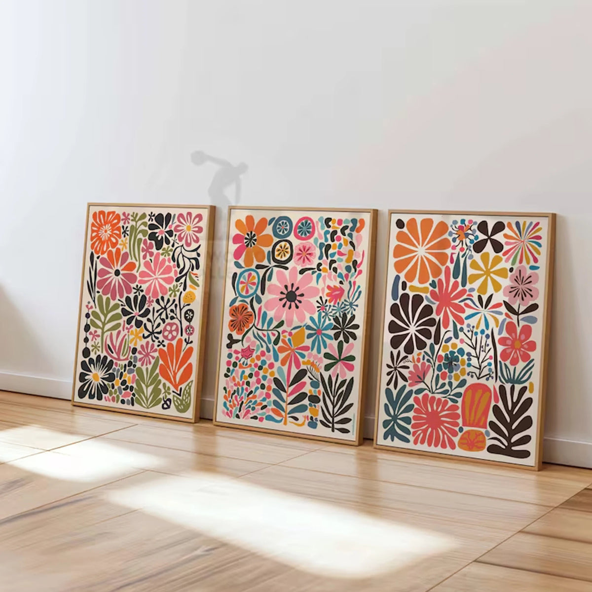 Un juego de cinco estampas florales botánicas enmarcadas con flores y follaje colorido sobre paneles de madera clara.