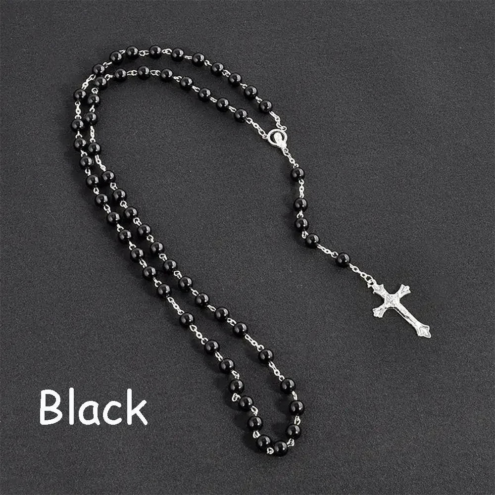 Black vintage cross and Virgin Mary pendant rosary necklace displayed on a dark background.