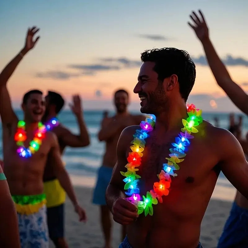 A man is smiling while wearing a colorful glow-in-the-dark LED Hawaiian lei necklace at a beach party.