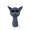 A dark gray collectible plush toy with large, sad eyes and a simple shape.