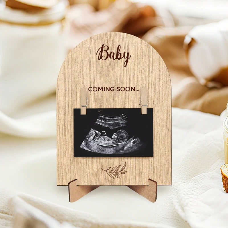 A wooden pregnancy announcement photo frame featuring an ultrasound image and the word Baby