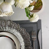 Elegant gold charger plates with silver detailing and white roses on a marble surface.