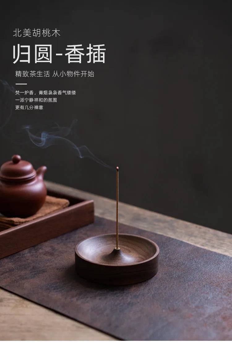 A dark brown solid wood incense stick burner with a thin metal stick emitting smoke on a wooden surface.